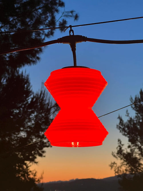 The Whirl lantern cover glowing red at sunset — Groovy Lanterns