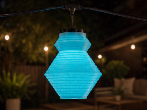 The Tumble lantern cover glowing blue over a patio at night — Groovy Lanterns